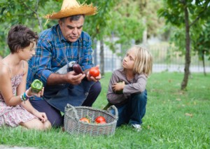 Grandfather teaching his grandkids about gardening.