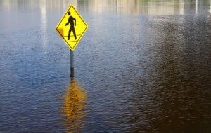 Crosswalk sign surrounded by high flood water.