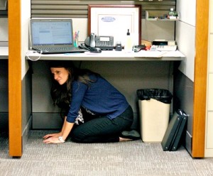 Sarah hiding under a desk