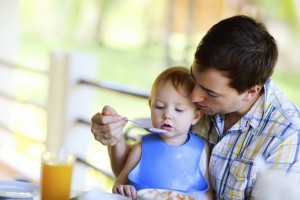 Young  father and his daughter having breakfast together