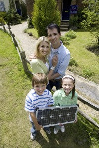 Family of four outdoors with solar panel, portrait, elevated view