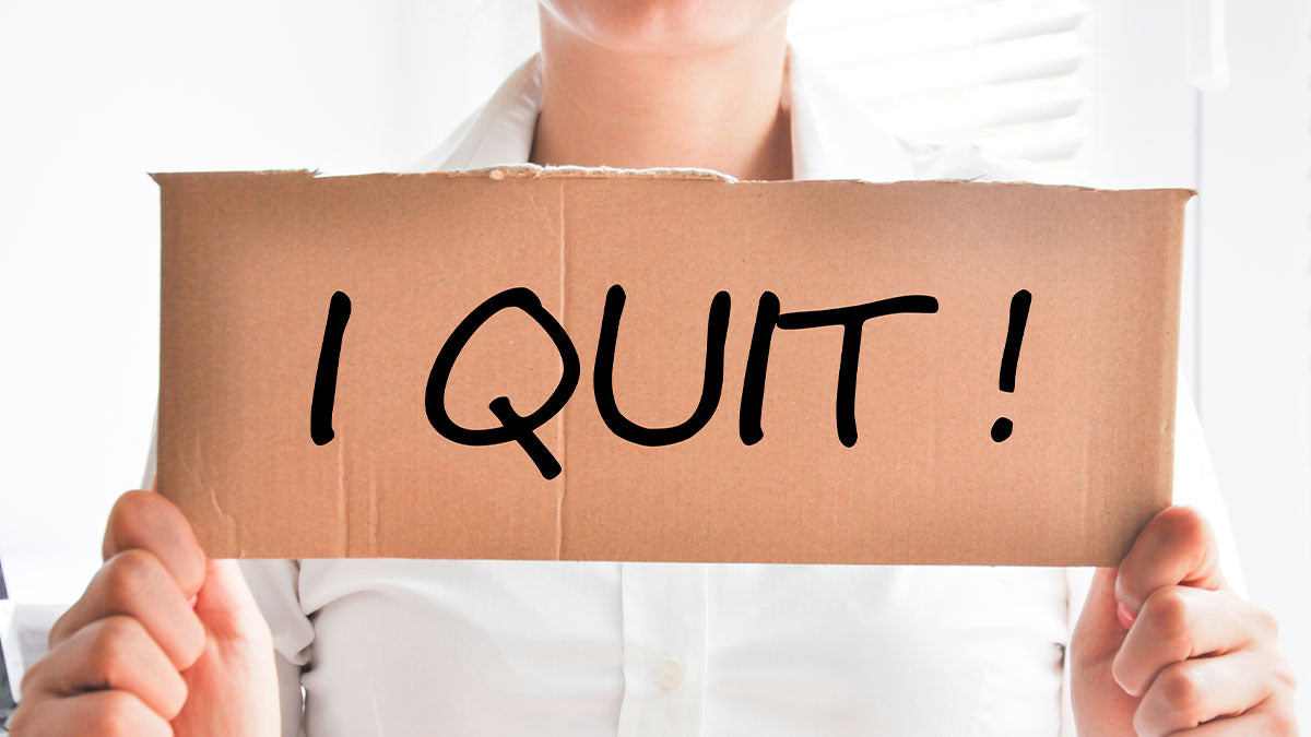 Woman holding a sign that says "I Quit"
