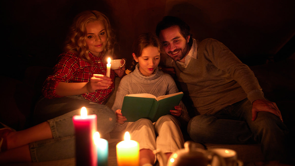 Family reading next to candle light