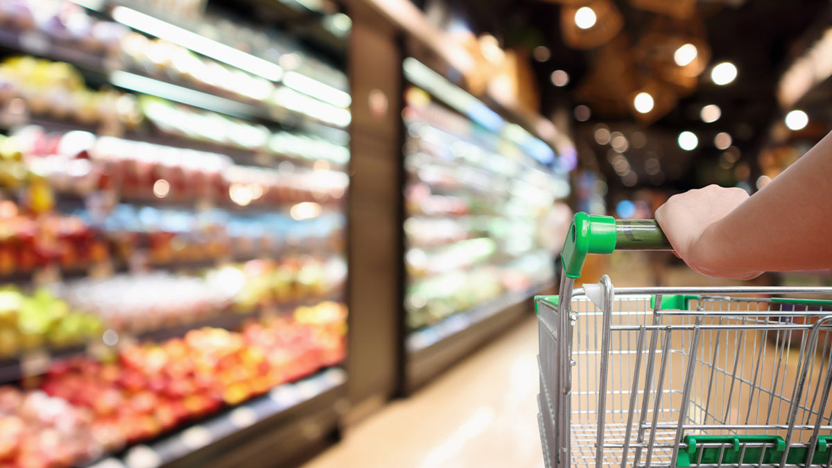 Pushing a grocery cart down the produce aisle