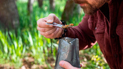 man camping in the woods eating a hot mre