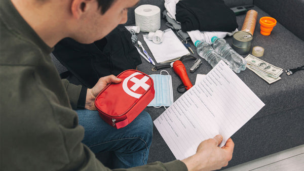 Man reading a survival kit list