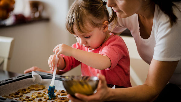 Mom and daughter making a batch of cookies in the kitchen