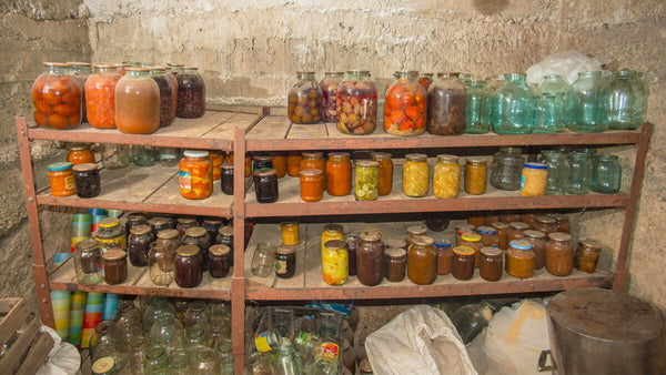 Shelves of jarred and canned food in a cellar.