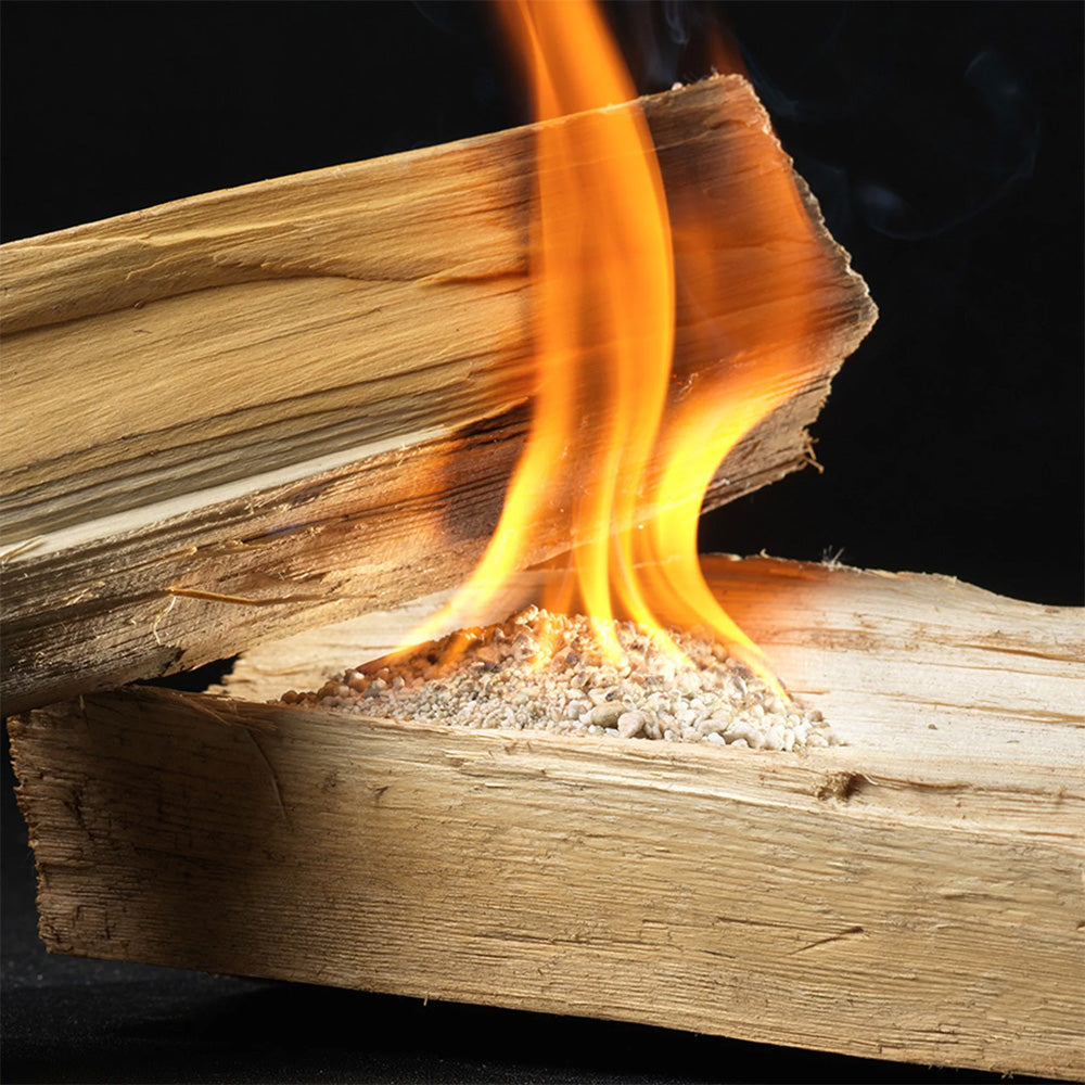 Orange flames burning on stacked firewood ignited with InstaFire Fire Starter & Fuel for outdoor fire starting.